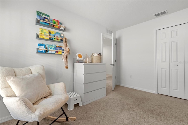 sitting room with carpet, visible vents, and baseboards