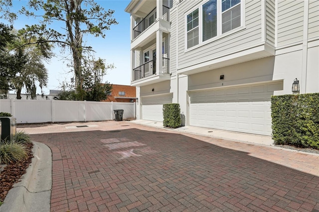 exterior space featuring fence, driveway, and stucco siding