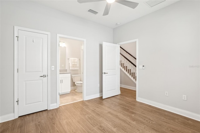 unfurnished bedroom with a ceiling fan, baseboards, visible vents, light wood-style flooring, and connected bathroom