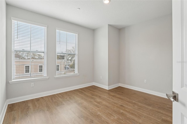 unfurnished room with wood finished floors and baseboards