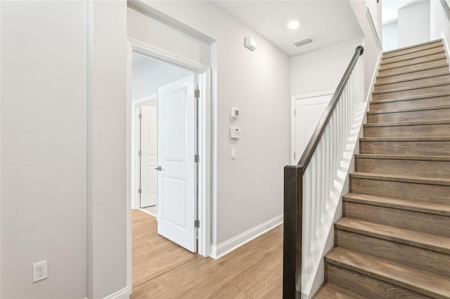 stairway featuring visible vents, recessed lighting, baseboards, and wood finished floors