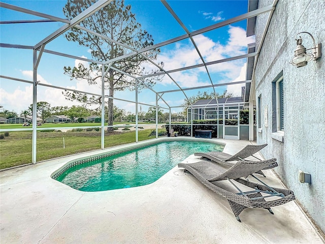 outdoor pool with a patio, a lawn, and glass enclosure