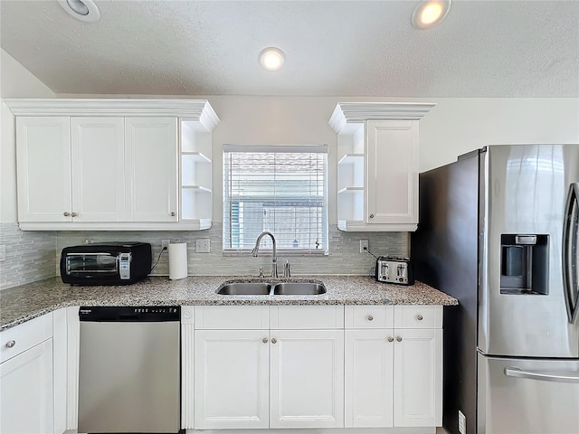 kitchen featuring open shelves, stainless steel appliances, decorative backsplash, white cabinets, and a sink