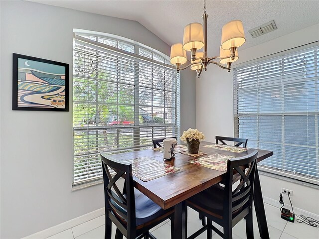 dining space with baseboards, visible vents, vaulted ceiling, a textured ceiling, and a chandelier