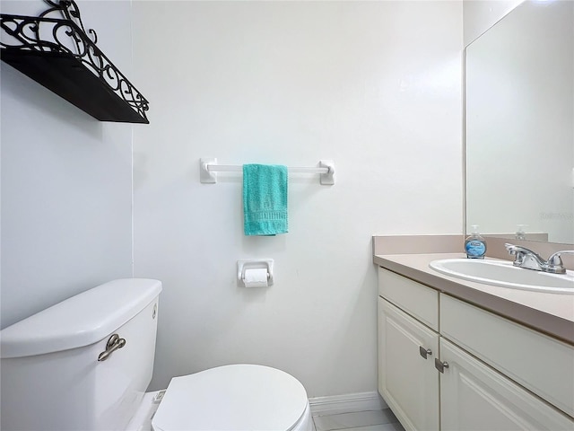 bathroom with vanity, toilet, and baseboards