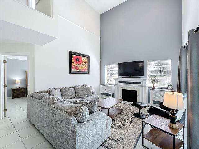 living room featuring a fireplace and a high ceiling