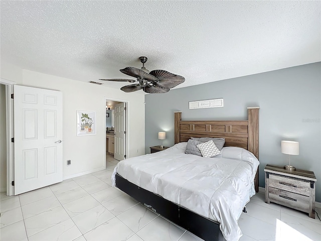 bedroom with a textured ceiling, visible vents, baseboards, a ceiling fan, and ensuite bath