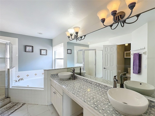 full bath with a notable chandelier, a sink, a bath, double vanity, and a stall shower