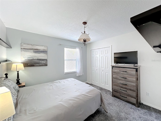 carpeted bedroom featuring a closet, baseboards, and a textured ceiling