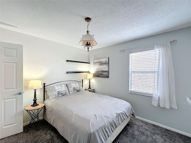 carpeted bedroom with baseboards and a textured ceiling