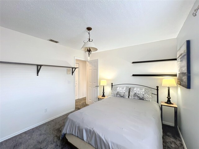 bedroom with baseboards, carpet, visible vents, and a textured ceiling