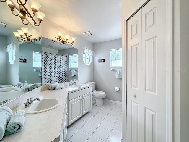 full bath featuring a notable chandelier, double vanity, toilet, a sink, and tile patterned floors