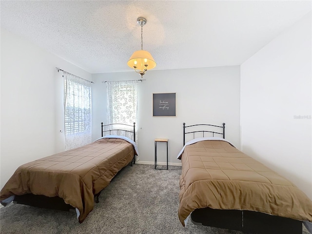 carpeted bedroom featuring baseboards and a textured ceiling