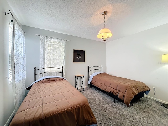 bedroom featuring carpet, baseboards, and a textured ceiling