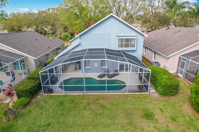 rear view of house featuring a lawn, a patio area, a lanai, and an outdoor pool