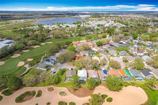 drone / aerial view with golf course view, a water view, and a residential view