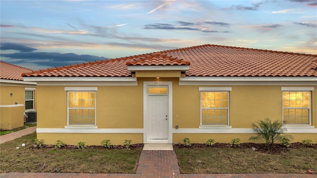 mediterranean / spanish home with central air condition unit and stucco siding