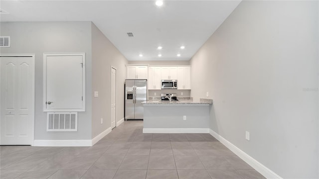 kitchen featuring stainless steel appliances, visible vents, a peninsula, and white cabinetry