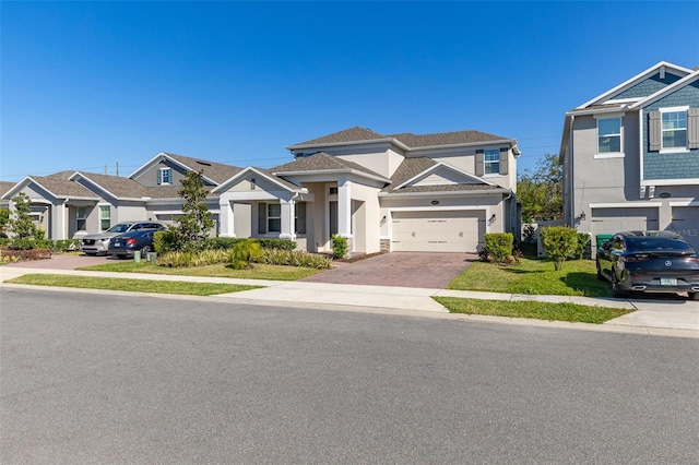 view of front facade featuring a garage, a residential view, driveway, and stucco siding