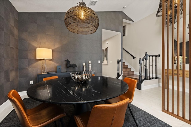 dining area featuring stairway, baseboards, high vaulted ceiling, and visible vents