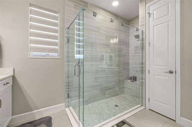 full bathroom with vanity, tile patterned floors, baseboards, and a shower stall