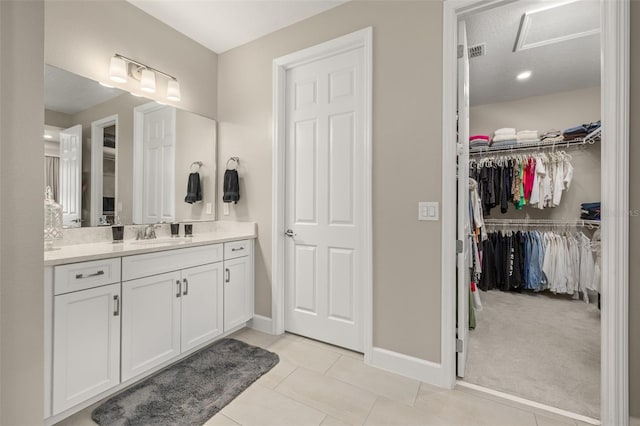 bathroom featuring a spacious closet, visible vents, baseboards, tile patterned floors, and vanity