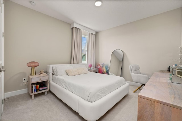 bedroom with light carpet and baseboards