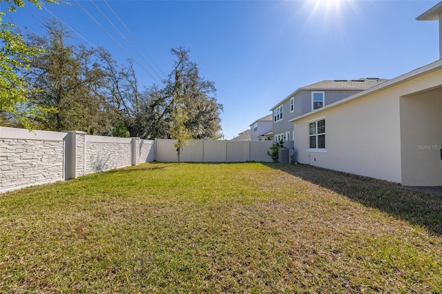 view of yard with central air condition unit and a fenced backyard