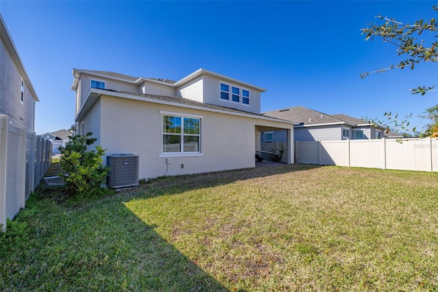 back of house with a yard, a fenced backyard, central AC, and stucco siding