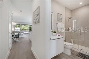 corridor with baseboards and wood finished floors