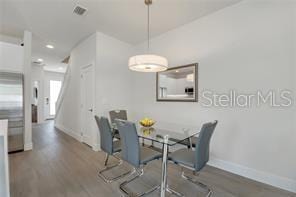 dining space featuring baseboards, visible vents, wood finished floors, and recessed lighting