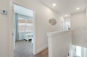 corridor with baseboards, carpet flooring, and recessed lighting