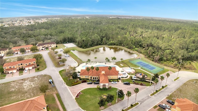 birds eye view of property featuring a water view and a wooded view