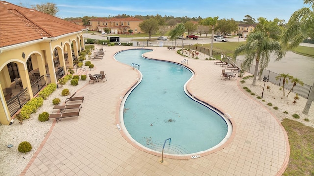 pool with a patio area and fence