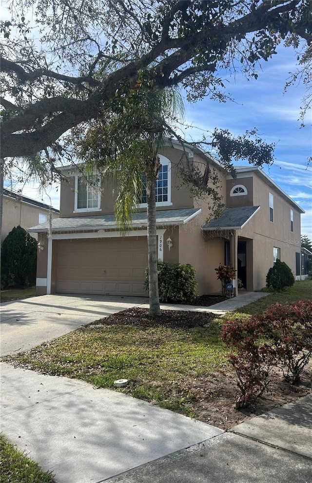 view of front facade with driveway, an attached garage, and stucco siding