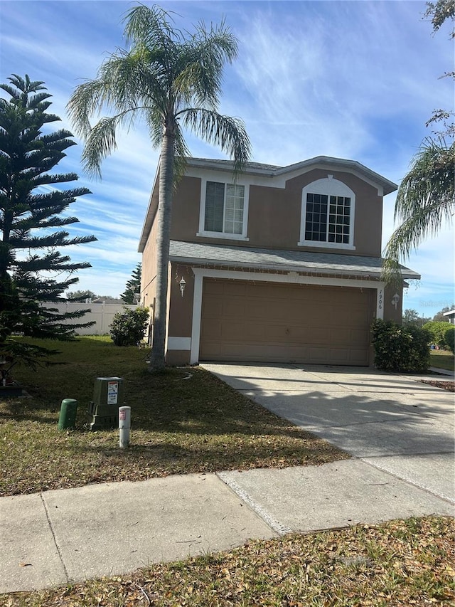 traditional home with stucco siding, a garage, and concrete driveway