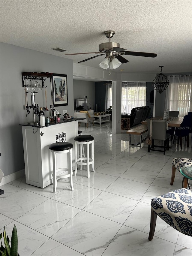 interior space with marble finish floor, baseboards, visible vents, and a ceiling fan