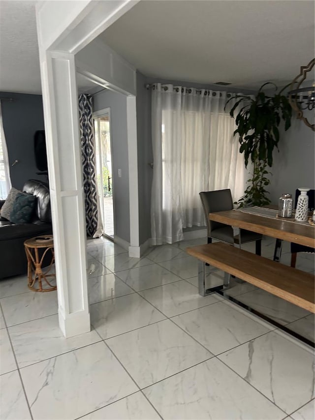 dining space with marble finish floor and baseboards