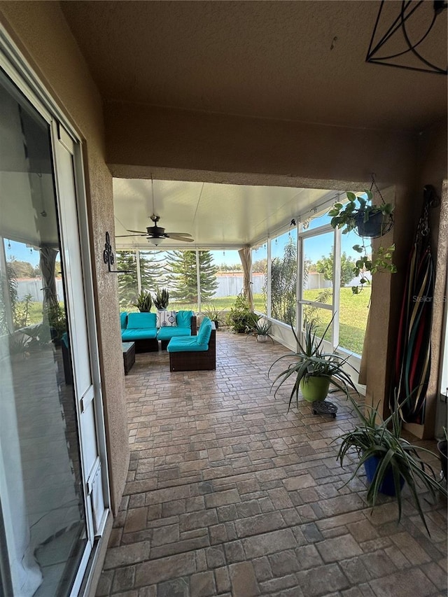 unfurnished sunroom featuring a wealth of natural light and a ceiling fan