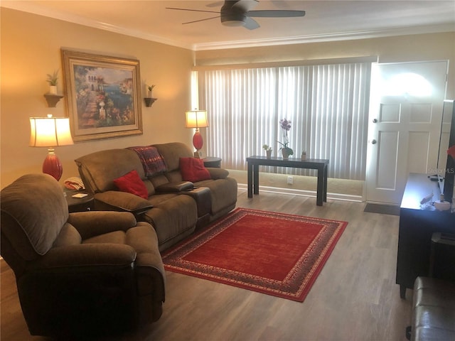 living area with a ceiling fan, crown molding, and wood finished floors