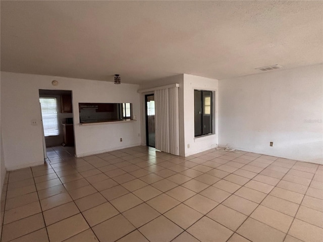 spare room featuring visible vents and light tile patterned floors