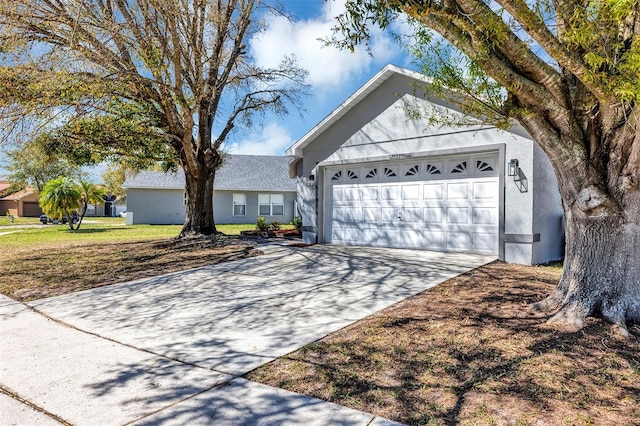 single story home featuring a garage, driveway, and stucco siding