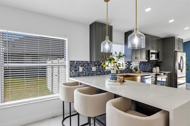 kitchen with recessed lighting, baseboards, hanging light fixtures, appliances with stainless steel finishes, and tasteful backsplash