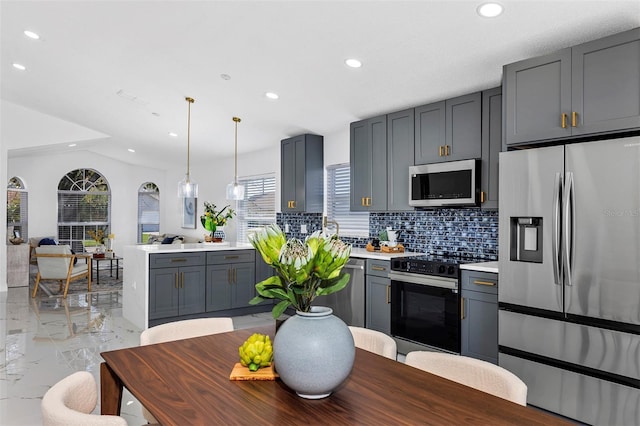 kitchen with marble finish floor, appliances with stainless steel finishes, plenty of natural light, and light countertops