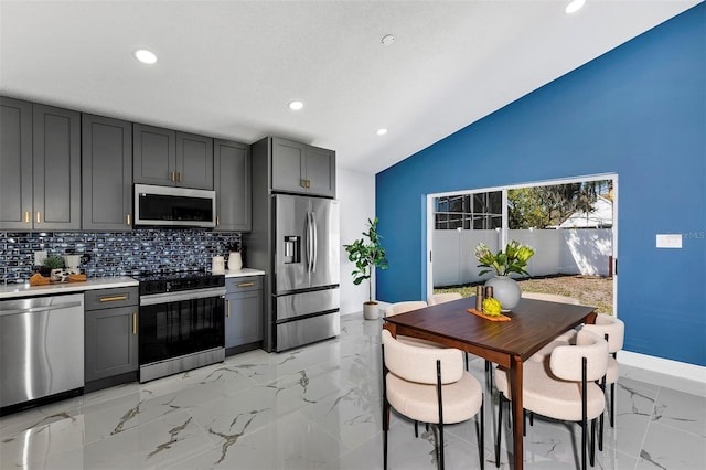 kitchen featuring marble finish floor, appliances with stainless steel finishes, light countertops, and backsplash