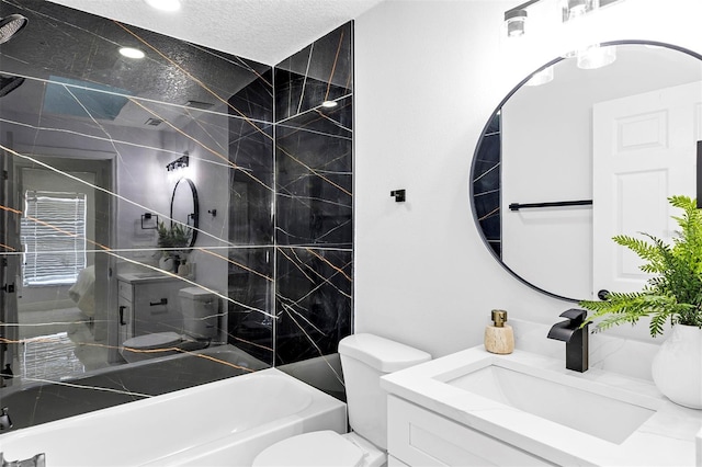 bathroom with a textured ceiling, bathtub / shower combination, vanity, and toilet