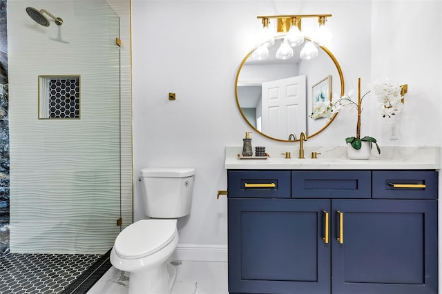 full bathroom featuring baseboards, a tile shower, vanity, and toilet