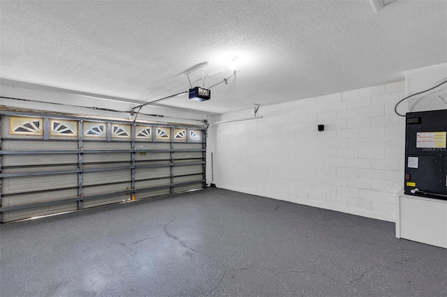 garage featuring concrete block wall and a garage door opener