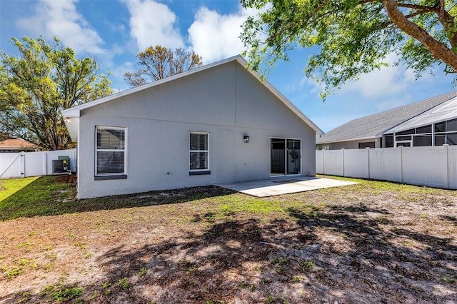 back of property with a yard, a fenced backyard, central AC unit, and a patio