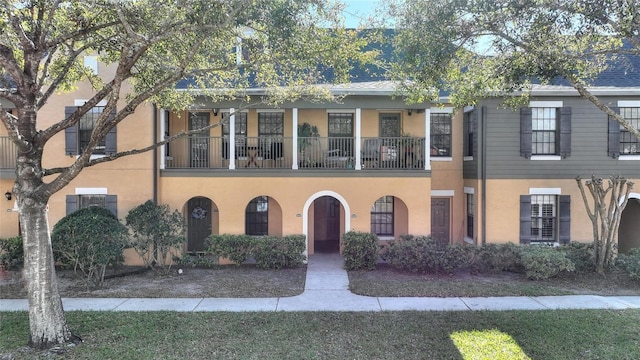 multi unit property featuring a balcony and stucco siding